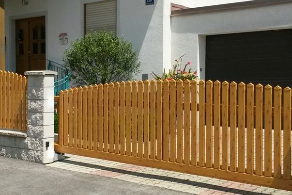 Clôture Lattes et capuchons pointus - Portail coulissant automatisé et clôture en couleur "bois", forme convexe.