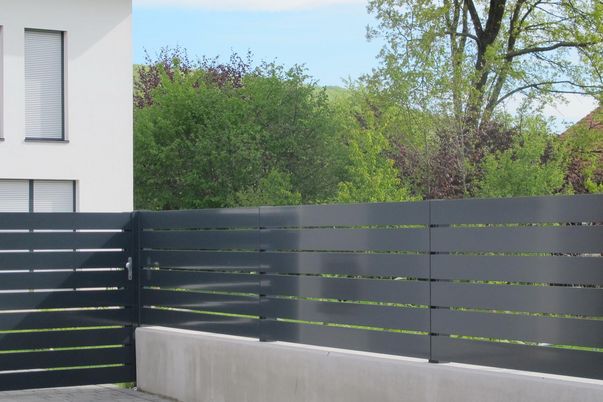 Portail & clôture Frontline - Portillon et clôtures et barreaux 150, posés devant les potelets.